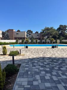 a stone patio with a pool in the background at Sea View Apartments Olimp- The sunny apartment in Olimp