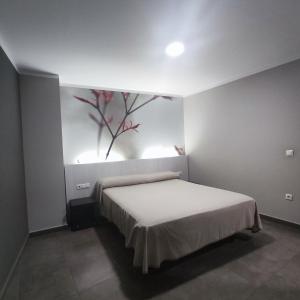 a bedroom with a bed with a painting on the wall at Aparthotel Meseguer in Alcañiz +37 photos