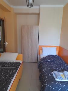 a small bedroom with two beds and a cabinet at Laki Apartments & Suites in Skopje