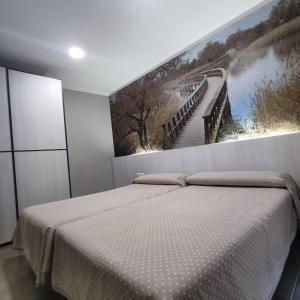 a bedroom with two beds and a painting on the wall at Aparthotel Meseguer in Alcañiz