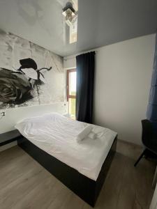 een slaapkamer met een bed en een schilderij aan de muur bij Apartamenty z widokiem na morze - przy plaży, SEA View in Dziwnówek