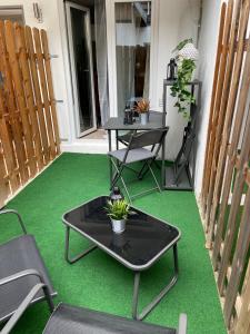 eine Terrasse mit einem Tisch und Stühlen auf einer grünen Etage in der Unterkunft Ferienwohnungen TalBach in Simmerath