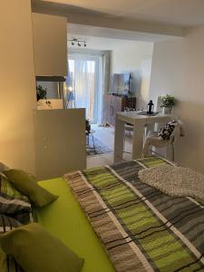 1 Schlafzimmer mit einem grünen Bett und einer Küche in der Unterkunft Ferienwohnungen TalBach in Simmerath