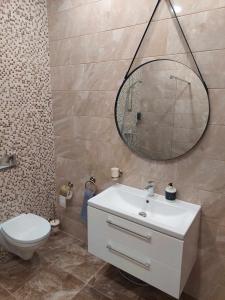 a bathroom with a sink and a toilet and a mirror at Sweet villa Palanga in Palanga