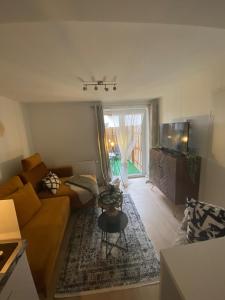 ein Wohnzimmer mit einem Sofa und einem TV in der Unterkunft Ferienwohnungen TalBach in Simmerath