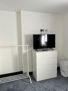 a living room with a tv on a white dresser at The Crouch - Apartment 2 in Grays Thurrock