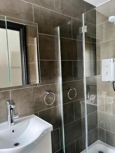 a bathroom with a shower and a sink and a mirror at The Crouch - Apartment 2 in Grays Thurrock