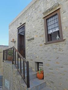 a stone building with a staircase and a window at Philoxeno Traditional house - Ano Syros in Ano Syros