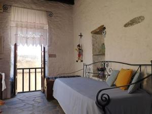 a bedroom with a bed and a window with a cross on the wall at Philoxeno Traditional house - Ano Syros in Ano Syros