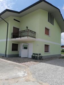 een groot wit huis met een balkon en 2 stoelen bij Colori nel Parco 2 in Cesiomaggiore