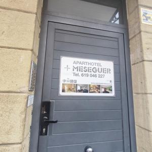 a blue door with a sign on top of it at Aparthotel Meseguer in Alcañiz