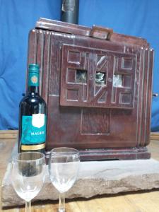 a bottle of wine and two glasses on a table at South Wales Yurt-Cosy, log burner & private garden 