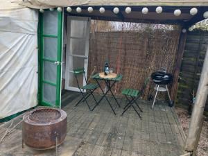 a patio with a table and chairs in a tent at South Wales Yurt-Cosy, log burner & private garden 