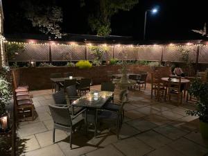 a patio with tables and chairs at night at White Horse Inn & Restaurant in Stoke Albany