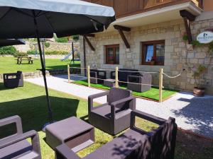 a patio with chairs and an umbrella in front of a house at Apartamentos Altamira in Santillana del Mar