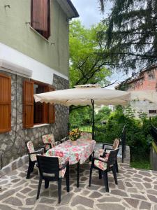 a table and chairs with an umbrella on a patio at Villa prestigiosa ampie metrature in Altipiani di Arcinazzo