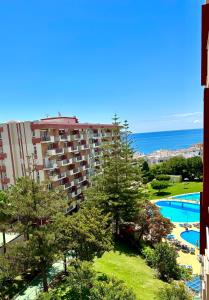 - une vue sur un hôtel avec une piscine et l'océan dans l'établissement Minerva Estudio Suite WHITE JASMINE, beach and pool BENALMADENA, à Benalmádena