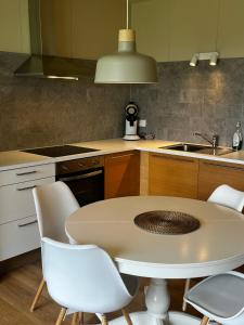 een keuken met een tafel en stoelen en een wastafel bij Bjarkarholt Guesthouse in Bjarkarholt