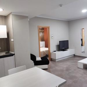 a living room with a room with a bed and a television at Aparthotel Meseguer in Alcañiz