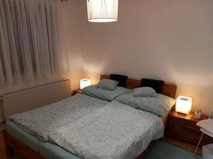 two beds in a bedroom with two lights on them at Ferienhaus in Maria Wörth