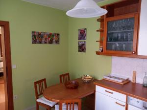 een keuken met een houten tafel met stoelen en een aanrecht bij Ferienhaus in Maria Wörth