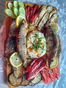 een bord met vis en andere voedingsmiddelen bij Skadar lake Apartments Pajovic in Virpazar