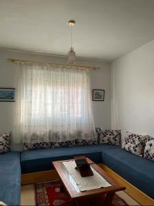 a living room with a blue couch and a table at Joli Appartement Propre et Équipé: Jardins d'Ifran in Ifrane