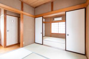 ein leeres Zimmer mit drei Türen und einem Fenster in der Unterkunft 貸別荘　満月の夜 in Minamiizu