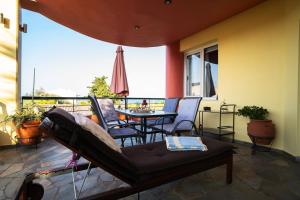 patio ze stołem i krzesłami oraz balkonem w obiekcie Vacation House in Agiokampos w mieście AgiaKampos