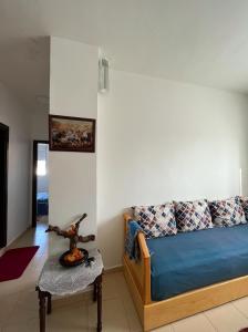 uma sala de estar com um sofá azul e uma mesa em Joli Appartement Propre et Équipé: Jardins d'Ifran em Ifrane