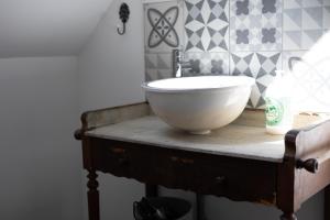 a bathroom with a bowl sink on a table at La romance de Laura in Arrest