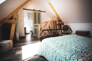 a bedroom with a bed and a wooden floor at La romance de Laura in Arrest