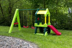 a playground with two swings in the grass at Dom Młynarza in Żukczyn