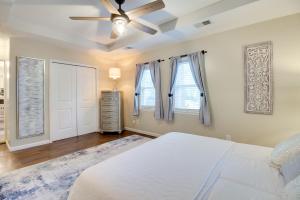 a bedroom with a white bed and a ceiling fan at Bright Guyton Home with Private Yard and Hot Tub! in Port Wentworth