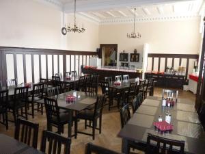 a restaurant with tables and chairs in a room at Hotel Pension Kima in Berlin