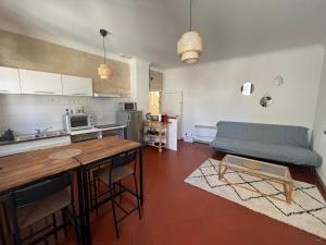 cocina y sala de estar con sofá y mesa en "Le central" Appart Arles en Arlés