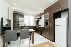 uma cozinha com uma mesa e um frigorífico em Elite Rentals Apartments em Chişinău