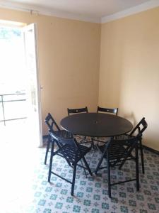 a black table and chairs in a room at Flat with sea view and garden in Framura