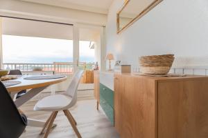 uma cozinha e sala de jantar com uma mesa e vista para o oceano em Atlantic Selection - Vue panoramique sur l'océan avec Parking em Hendaye