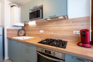uma cozinha com um balcão com um fogão e um lavatório em Atlantic Selection - Vue panoramique sur l'océan avec Parking em Hendaye