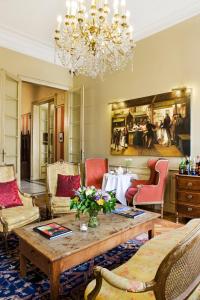 a living room with a table and chairs and a chandelier at Martin's Relais in Bruges