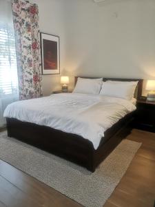 1 dormitorio con 1 cama grande con sábanas y almohadas blancas en Little Garden private pool villa en Al Ḩamrāʼ