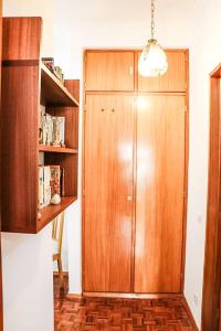 a wooden door in a room with a book shelf at Casa da Mariazinha in Costa da Caparica