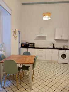 - une cuisine avec une table et des chaises en bois dans l'établissement Precioso Apartamento: La Luz de Cádiz, à Cadix