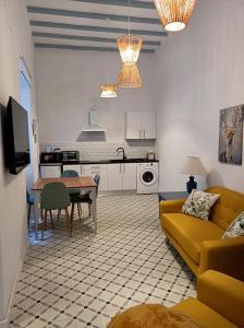 a living room with a yellow couch and a table at Precioso Apartamento: La Luz de Cádiz in Cádiz