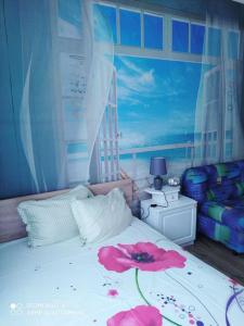 a bedroom with a bed with a flower on it at Къща за Гости Тера in Kiten