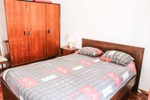 コスタ・ダ・カパリカにあるCasa da Mariazinhaのベッドルーム1室(ベッド1台、木製キャビネット、枕2つ付)