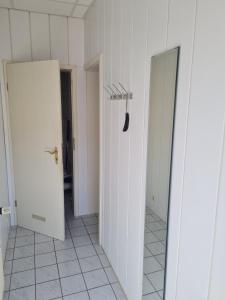 a hallway with two white doors and a black shovel at Ferienwohnung Ribnitz-Damgarten in Ribnitz-Damgarten