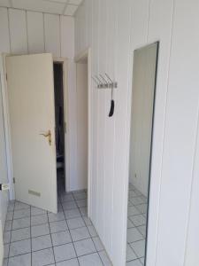 un corridoio con due porte bianche e una pala nera di Ferienwohnung Ribnitz-Damgarten a Ribnitz-Damgarten Altre 5 foto