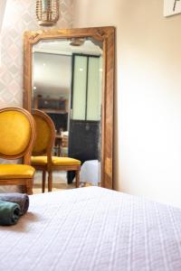 アレストにあるLa ferme de Mademoiselle Jeanneのベッドルーム1室(ベッド1台、鏡、椅子付)